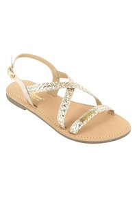 Cinghie intrecciate in oro metallico con un cinturino alla caviglia sul retro sono abbinate a una suola piatta color nocciola. Il design presenta un accento con il logo sulla soletta.