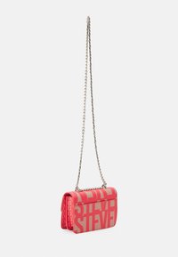 Rød og beige crossbody taske med fede blokbogstaver og en sølv kædetrøje på en hvid baggrund.