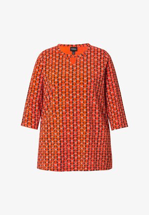Orangenfarbendes Oberteil mit rundem Halsausschnitt, das ein geometrisches Design in verschiedenen Farbtönen und Formen aufweist, 3/4-Ärmel und einen lockeren Schnitt hat.