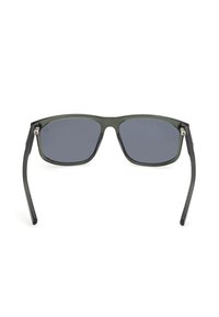 Prostokątne okulary przeciwsłoneczne z ciemnoszarymi soczewkami, zieloną przezroczystą oprawką i czarnymi ramionami. Posiadają metalowe akcenty w okolicy zawiasów.