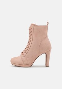 Stivaletto alla caviglia in suede rosa con punta arrotondata, apertura con lacci e tacco alto. Anello sul retro per indossarlo facilmente; texture liscia.