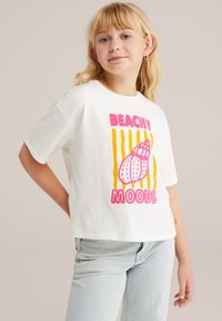 Balta medvilninė marškinėliai su trumpomis rankovėmis, pustoniais "BEACHY MOODS" rožine ir geltona spalvomis. Dizainas apima kriauklės grafiką ir horizontaliąsias juosteles.