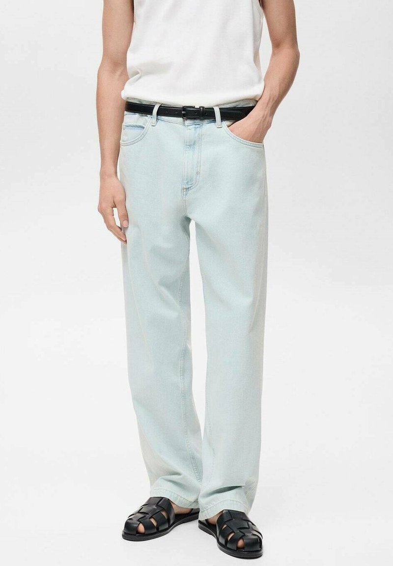 Lichtblauwe denim jeans met een relaxte pasvorm, vijf zakken en een recht gesneden ontwerp, gecombineerd met een zwarte riem en zwarte gevlochten sandalen.
