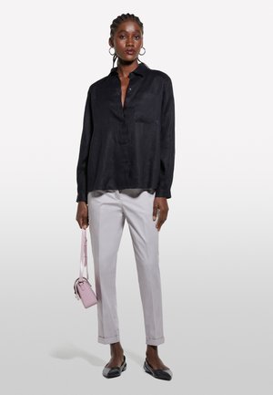 Chemise boutonnée en lin noir, pantalon gris sur mesure, sac à bandoulière rose et ballerines noires à bouts ronds. Design simple et coupe décontractée.
