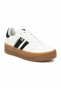 Sneaker bianco con strisce nere, punta rotonda, pelle testurizzata e suola in gomma marrone. Presenta lacci bianchi e un accento sul tallone.