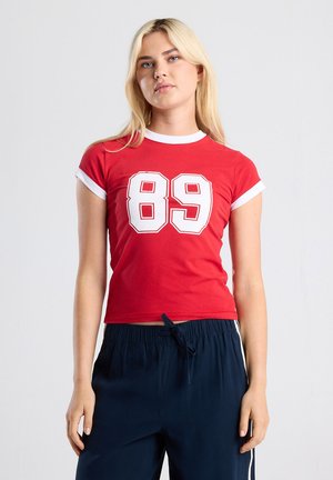 Red cotton t-shirt with white trim, featuring a bold '89' graphic on the front. Fitted style with short sleeves and a cropped length.
