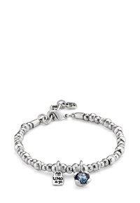 Pulsera de cuentas plateadas con cierre de langosta, que incluye dos dijes: una pequeña placa grabada con "UNO de 50" y una piedra preciosa azul en un engaste de plata.