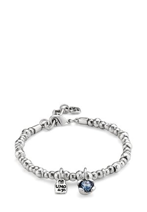 Pulsera de cuentas plateadas con cierre de langosta, que incluye dos dijes: una pequeña placa grabada con "UNO de 50" y una piedra preciosa azul en un engaste de plata.