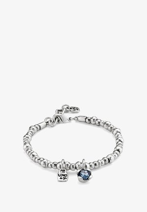 Pulsera de cuentas plateadas con cierre de langosta, que incluye dos dijes: una pequeña placa grabada con "UNO de 50" y una piedra preciosa azul en un engaste de plata.