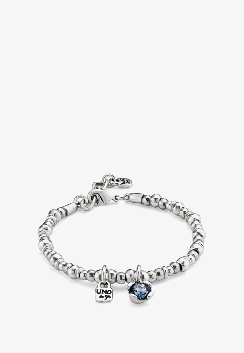 Pulsera de cuentas plateadas con cierre de langosta, que incluye dos dijes: una pequeña placa grabada con "UNO de 50" y una piedra preciosa azul en un engaste de plata.