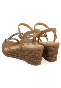 Sandalias de cuña marrones con correas cruzadas y un acento de cuentas moradas, tacón de cuerda tejido texturizada y plantilla suave.