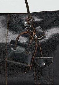 Borsa tote in pelle nera con una finitura liscia e lucida. Include una piccola borsa a pochette in pelle nera attaccata e una mini borsa, entrambe con superfici testurizzate.
