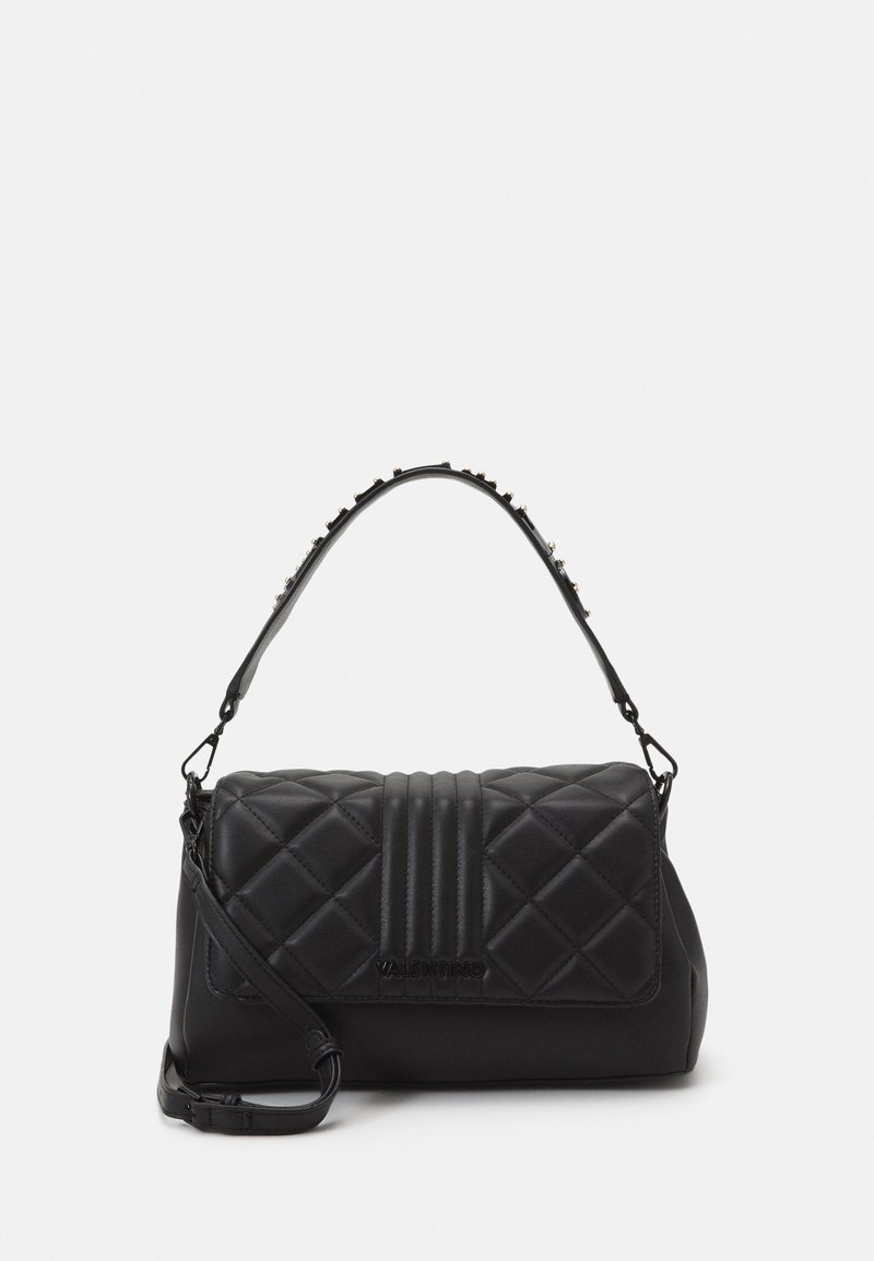 Black quilted leather handbag with a structured shape, featuring a top handle with studded accents and an adjustable shoulder strap.