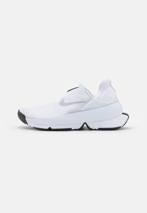 Chaussure de sport blanche sans lacets avec tige en mesh respirant, semelle épaisse texturée et détails noirs sur la pointe et les bords de la semelle, vue de côté.