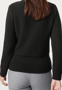 Svart stickad tröja med ett texturerat mönster, avskuren ribbad nederkant och långa ärmar, visad bakifrån mot en neutral bakgrund.