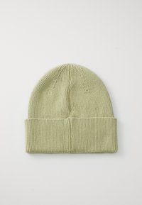 Beanie lavorato a maglia di colore verde chiaro, con un polsino a coste e un design senza cuciture nella parte superiore. Texture morbida con dettagli di cucitura sottili.