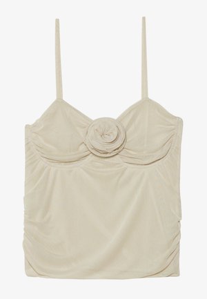 Beżowa bezrękawnik z detalem w kształcie róży na środku, wykonany z teksturowanej tkaniny i z marszczeniami po bokach, co nadaje dopasowany wygląd.