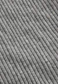 Szürke bordázott szövet, függőleges csíkokkal, amelynek puha textúrája és bolyhos megjelenése van. A minta diszkrét és egyenletesen elosztott.