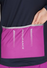 Marineblå och rosa sporttopp med bakficka, reflexdetaljer och en smidig, lätt design för förbättrad prestanda och synlighet.