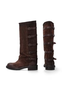 Hnědé semišové kozačky ke kolenům s kulatou špičkou, zdobené pěti nastavitelnými koženými pásky a přezkami po vnější straně. Plochý podpatek.