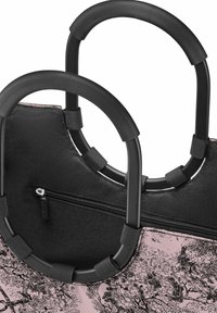 Sac fourre-tout en tissu noir avec des poignées en caoutchouc noir. Il dispose d'une poche zippée et d'un corps rose orné d'un motif d'arbre texturé en noir.