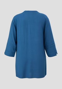 Blaues Tunikabluse mit 3/4-Ärmeln, weichem Stoff, gerader Schnitt und zwei horizontalen Nähten an den Ärmeln. Mit einem runden Halsausschnitt.