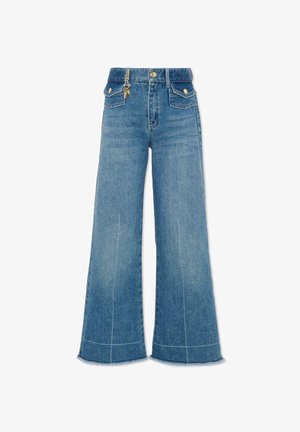 Jean bleu taille haute à jambes larges avec poches avant, détails de boutons dorés, et un petit charm doré attaché près de la ceinture.