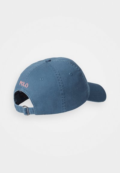 Cască de baseball din bumbac albastru, cu o margine curbă, un sistem de ajustare la spate și "POLO" brodat în roz pe partea din spate.