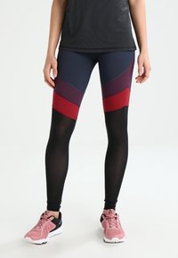 Legginsy o wysokiej wydajności w kolorach granatowym, burgundowym i czarnym. Posiadają design z blokowaniem kolorów, dopasowany krój oraz elastyczny materiał.