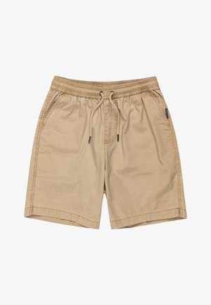 Dreng iført en orange Quiksilver T-shirt, beige shorts, sorte Quiksilver strømper og sorte sneakers med hvide snørebånd og gummisåler.