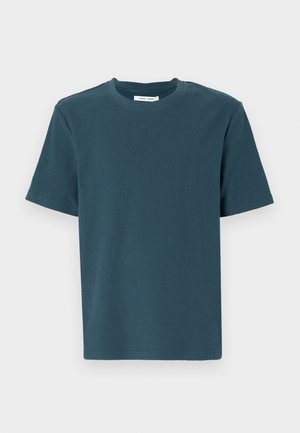 Tricou scurt cu mânecă, de culoare teal închis, cu guler rotund. Fabricat dintr-un material moale, texturat. Croială dreaptă, fără modele sau accente.
