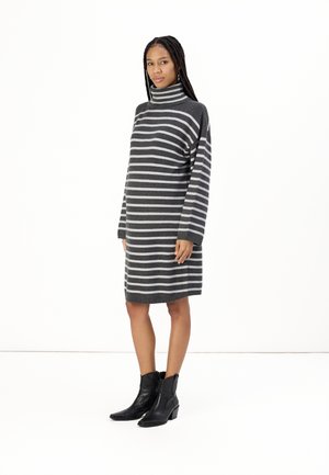 Gray and white striped turtleneck dress with long sleeves, knee-length, made from knitted material, paired with black ankle boots.