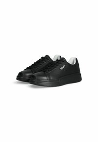 Sneaker in pelle nera con punta arrotondata, design con lacci e bordo bianco. Presenta un logo del marchio sul lato e una suola nera spessa.