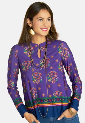 Lila Langarmoberteil mit Blumenmuster, Schlüsselloch-Ausschnitt, kontrastierendem gestreiftem Saum und vielschichtigen, bunten Details.