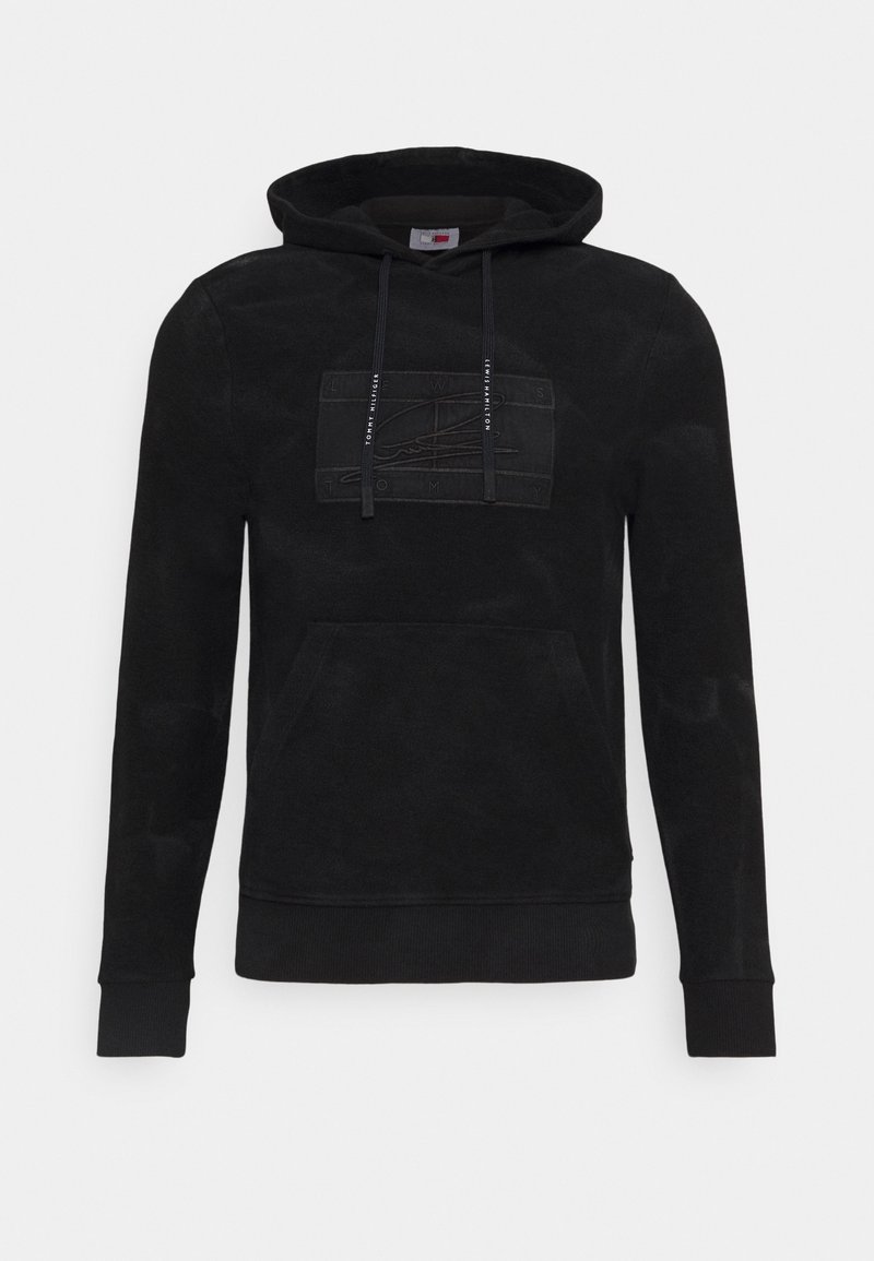 Sweat à capuche noir avec poche avant, cordons imprimés "Tommy Hilfiger" et patch logo rectangulaire subtilement cousu sur la poitrine.