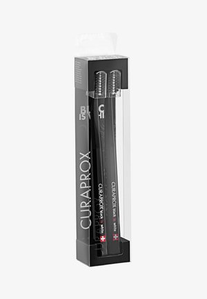Spazzolini Curaprox neri in confezione trasparente, con setole morbide, un manico elegante e testi e accentuazioni bianche distintive.