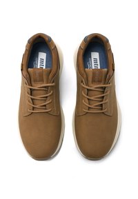 Zapatillas sintéticas marrones con un acabado texturizado, puntera redonda, diseño con cordones y suela de goma clara en contraste. Plantilla azul con logotipo.