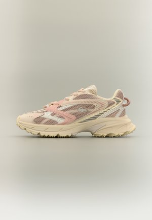Baskets de sport rose clair et beige avec dessus en mesh, semelle texturée et languette au talon sur un fond clair uni.