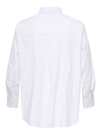 Valge pika varrukaga särgi, millel on krae, tagumine õlakate ning keskelt allapoole paigaldatud voldi detail.