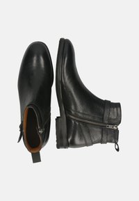 Botines de cuero negro con acabado texturizado, cierre lateral con cremallera y suela de goma plana. Punta redondeada y diseño minimalista.