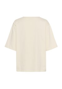 Kortærmet, løs t-shirt i lys creme bomuld. Har en rund halsudskæring og ingen synlige tryk eller udsmykninger.