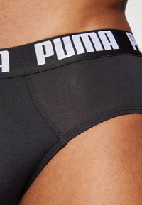 Boxeri negri din bumbac cu o textură netedă, talie elastică cu branding alb "PUMA" și o fixare strânsă pe corp.