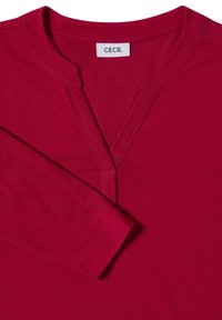 Rode lange mouwen top met een V-hals en subtiele stikseldetails. Gemaakt van gladde stof, voorzien van een label met de merknaam "CECIL."