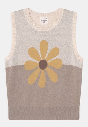 Pull sans manches tricoté beige clair avec un grand motif de fleur jaune et une section inférieure beige plus foncé. Col et ourlet côtelés.