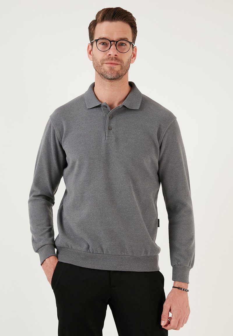 Grijze langelijf polo met lange mouwen, kraag, een drieknopen-lijst, ribgebreide manchetten en een rechte zoom. Zachte stoftextuur. Zwarte logo-tag.