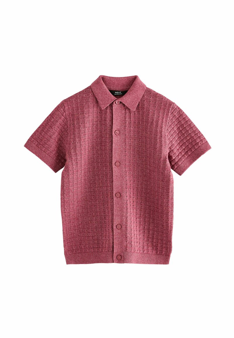 Chemise à manches courtes, texturée, de couleur rose foncé avec un col boutonné, présentant un motif à carreaux et cinq boutons sur le devant.