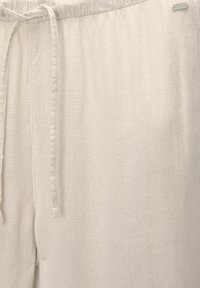 Lichtbeige linnen broek met een elastische tailleband en trekkoord, met een gladde textuur en minimale stikseldetails.