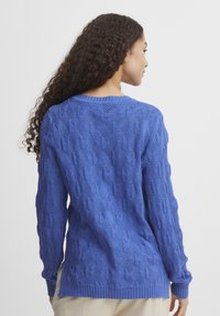 Maglione azzurro lavorato a maglia con un motivo a rombi testurizzato, polsini e orlo a coste, e scollo tondo. Adatto per un abbigliamento casual.