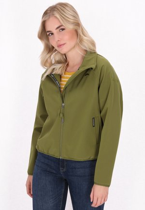 Jachetă verde din material softshell cu fermoar frontal, guler în picioare și două buzunare laterale. Asociată cu un top alb cu dungi galbene și blugi albaștri.