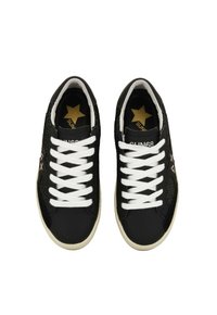 Sneakers neri con lacci bianchi, pannelli laterali in mesh, dettagli a stella dorata sulla linguetta e suola in gomma. Il design presenta una silhouette sportiva.